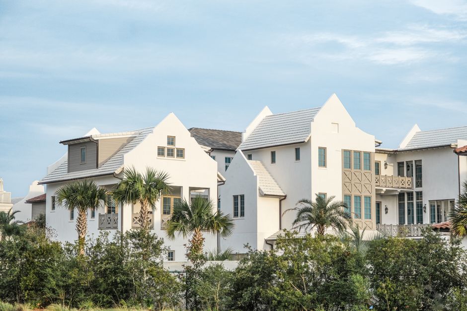 A beautiful, modern coastal home with a pristine roof basking in bright sunshine, representing security and peace of mind.